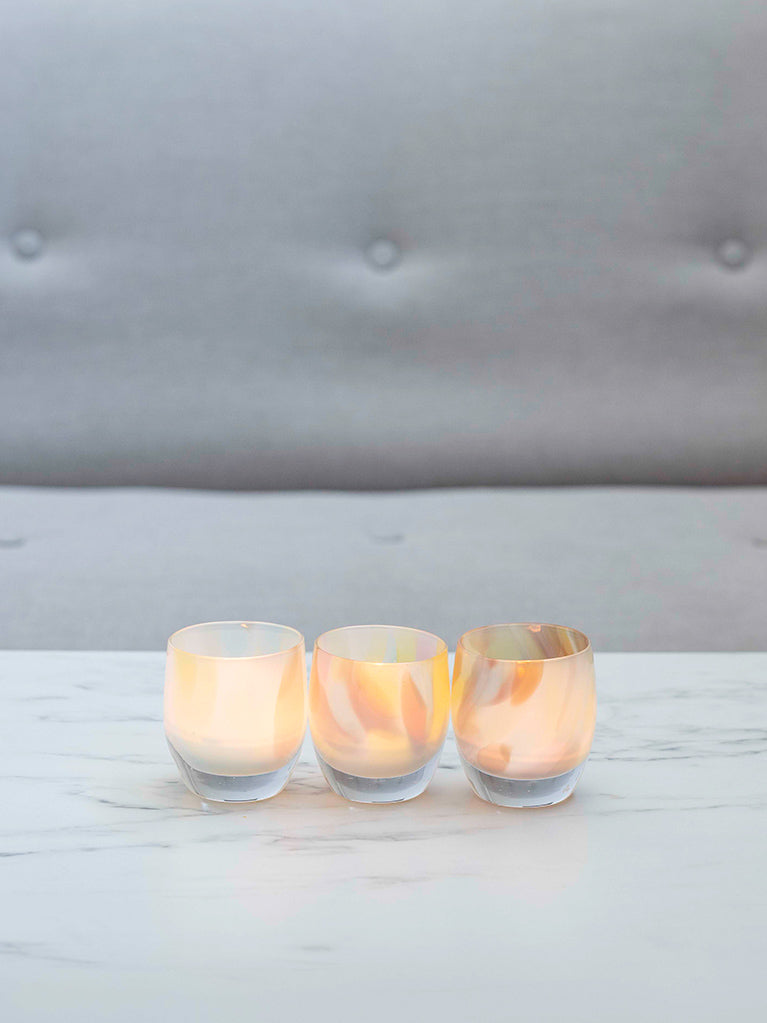 pastel colors collide in so much fun, a hand-blown glass candle holder perfect for mother's day, resting on a marble table.