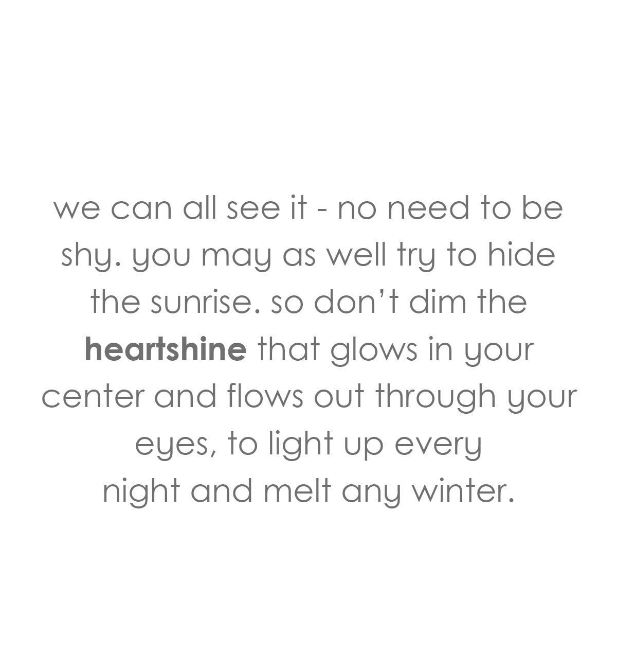 heartshine, shimmering glitter that enrobes the top of a bright red base, hand-blown glass votive candle holder on a dark table with cream wall behind and a vase of green leafed stems.