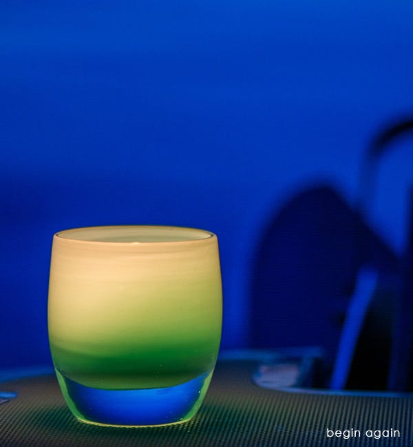 begin again light teal, hand-blown glass votive candle holder lit on a boat.