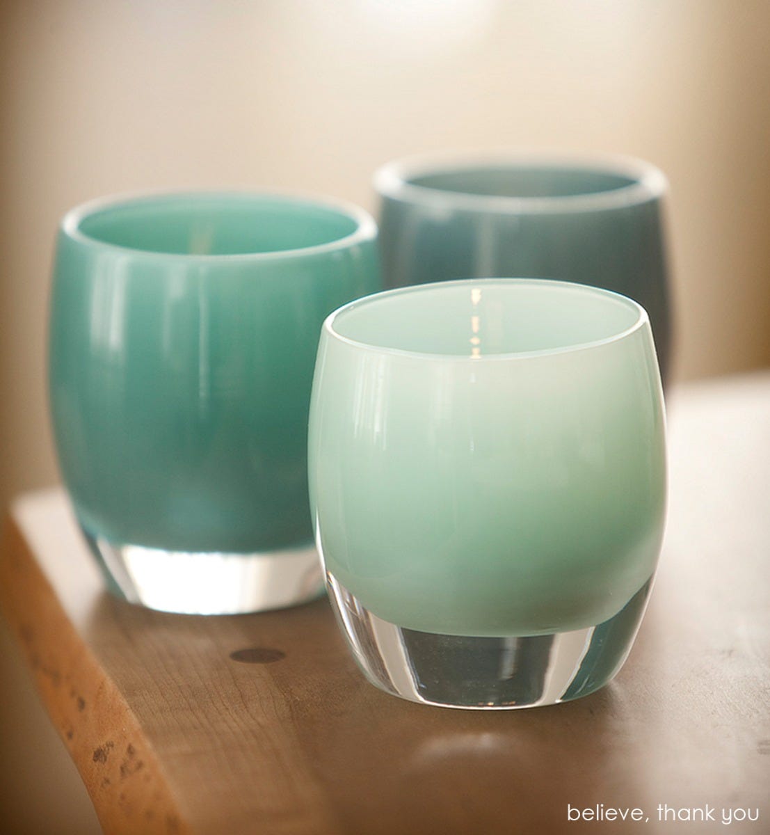 believe hand-blown soft pine green glass votive candle holder. Paired with thank you.