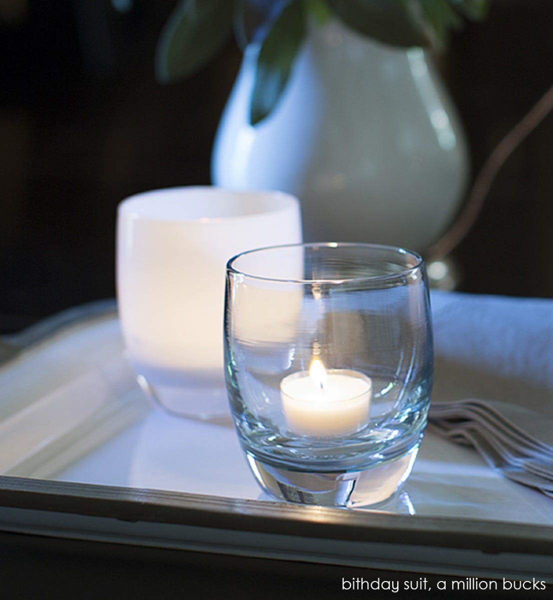 birthday suit, with touch of green clear hand-blown glass votive candle holder. Paired with a million bucks.