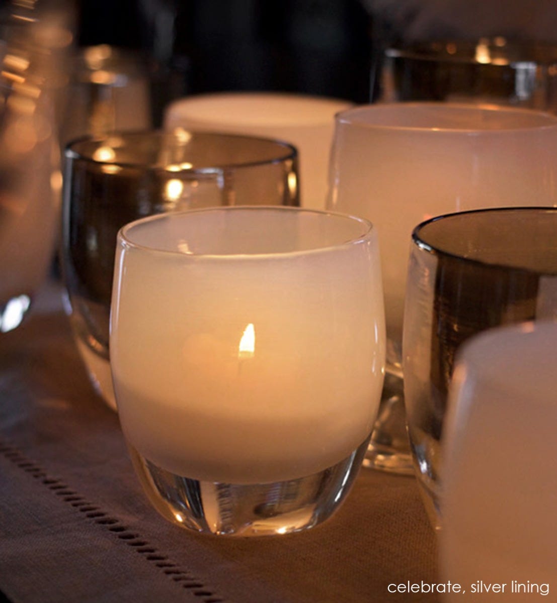 celebrate snow white hand-blown glass votive candle holder. Paired with silver lining.