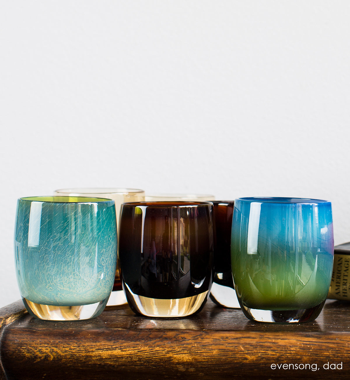 dad translucent dark brown hand-blown glass votive candle holder. Paired with evensong on a dark wood table.