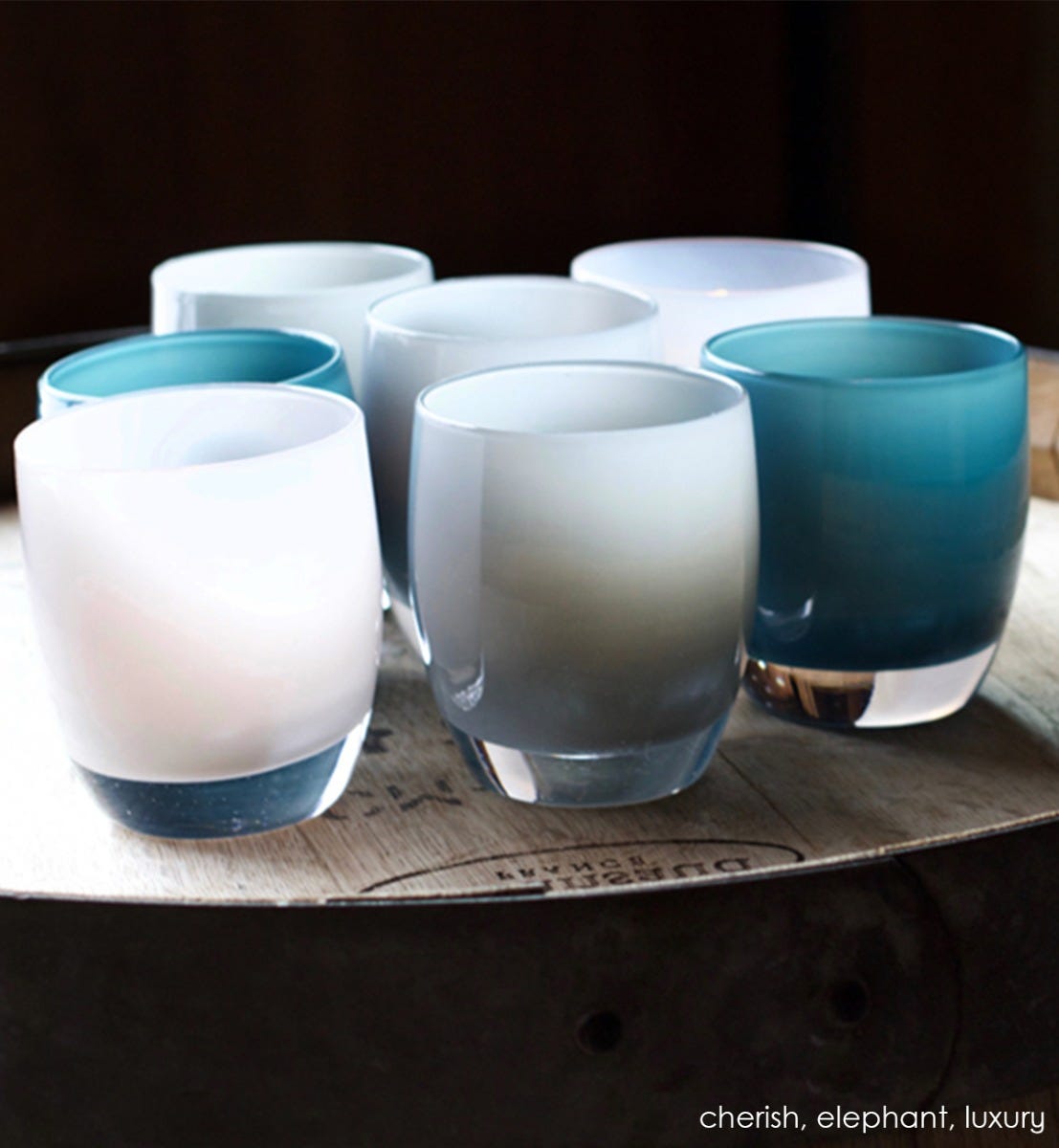 elephant shaded gray hand-blown glass votive candle holder. Paired with cherish and luxury.