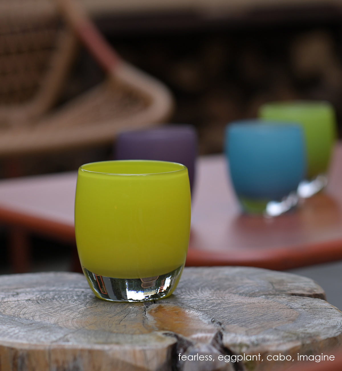 fearless bright yellow hand-blown glass votive candle holder. Paired with eggplant, cabo, and imagine on wood stump.