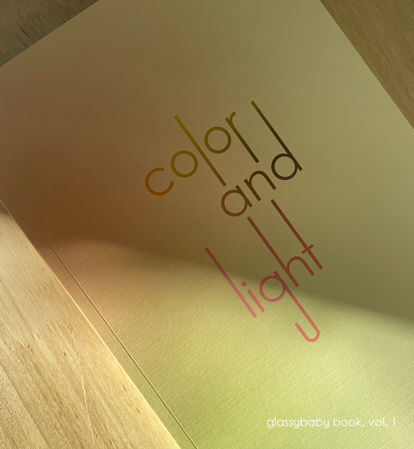 coffee table book of glassybaby volume one on a light wood table.