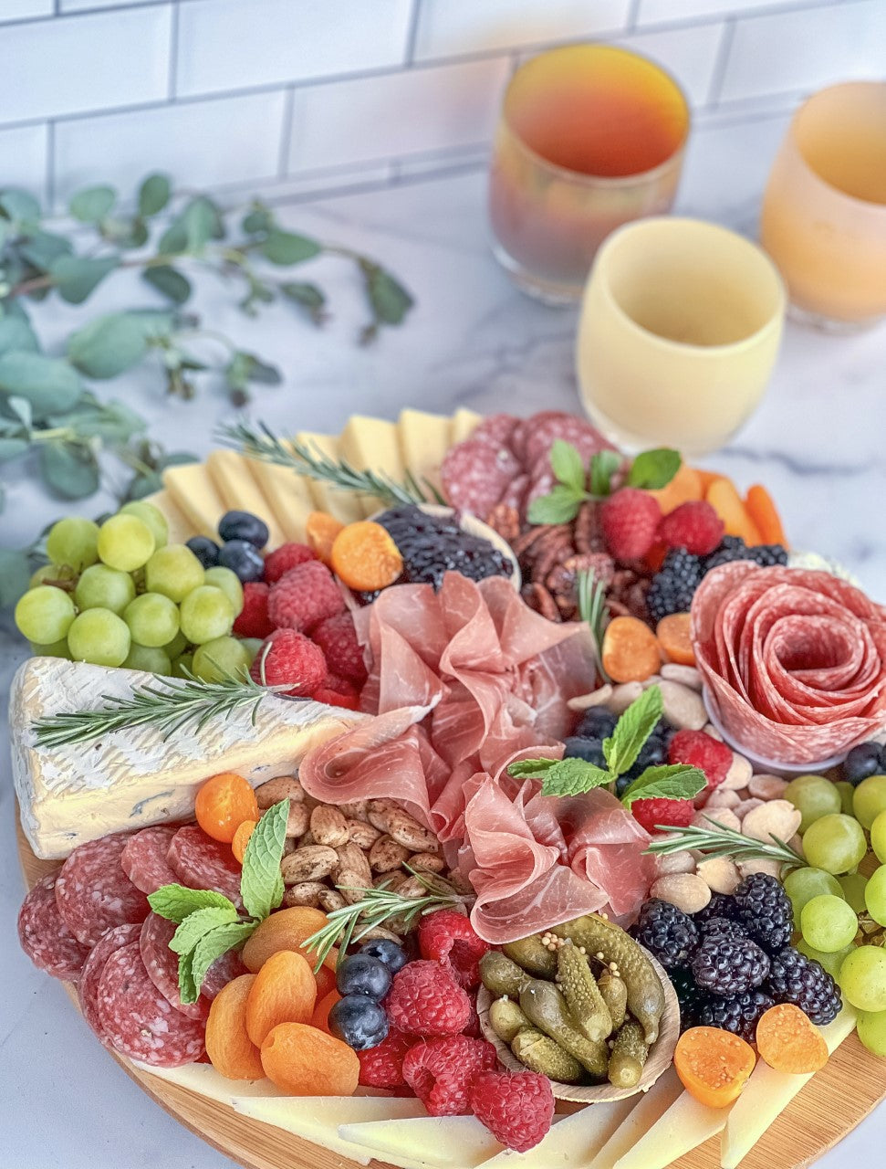 charcuterie board by gateboards next to cream, brown and yellow glassybaby.