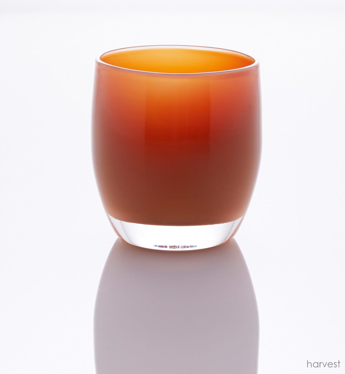 harvest deep orange hand-blown glass votive candle holder in a white setting.