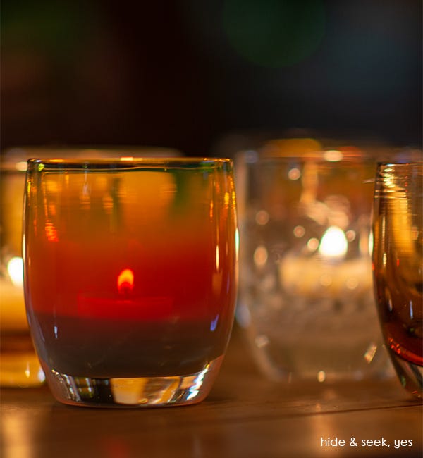 hide and seek autumn tone hand-blown glass votive candle holder lit with yes votive.