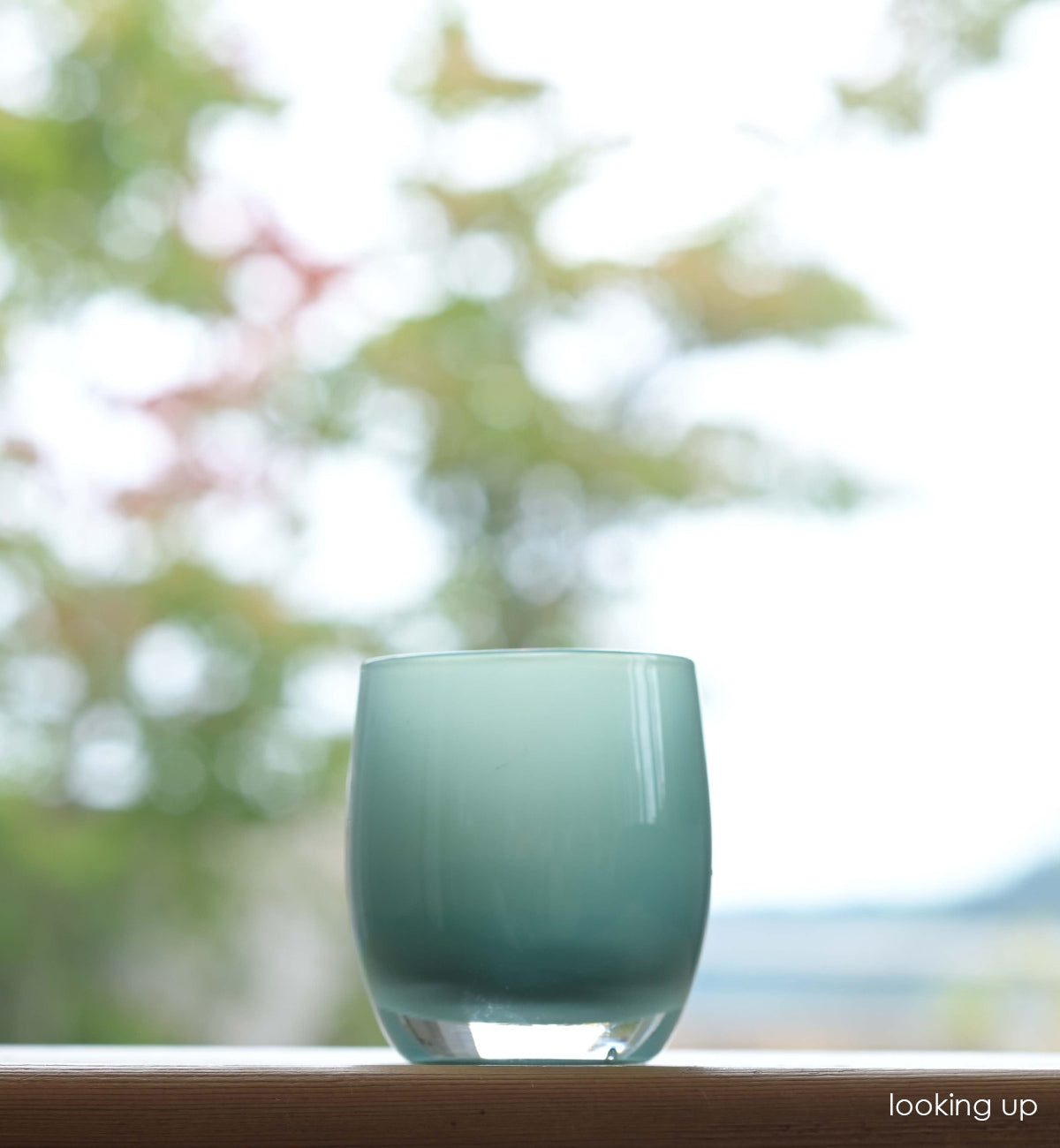 looking up hand-blown aqua glass votive candle holder. 