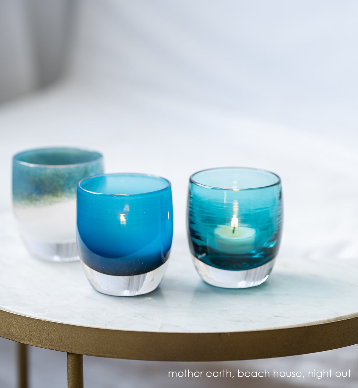 night out dark aqua blue transparent, hand-blown glass votive candle holder. paired with mother earth metallic blue green on white, and beach house blue gradient
