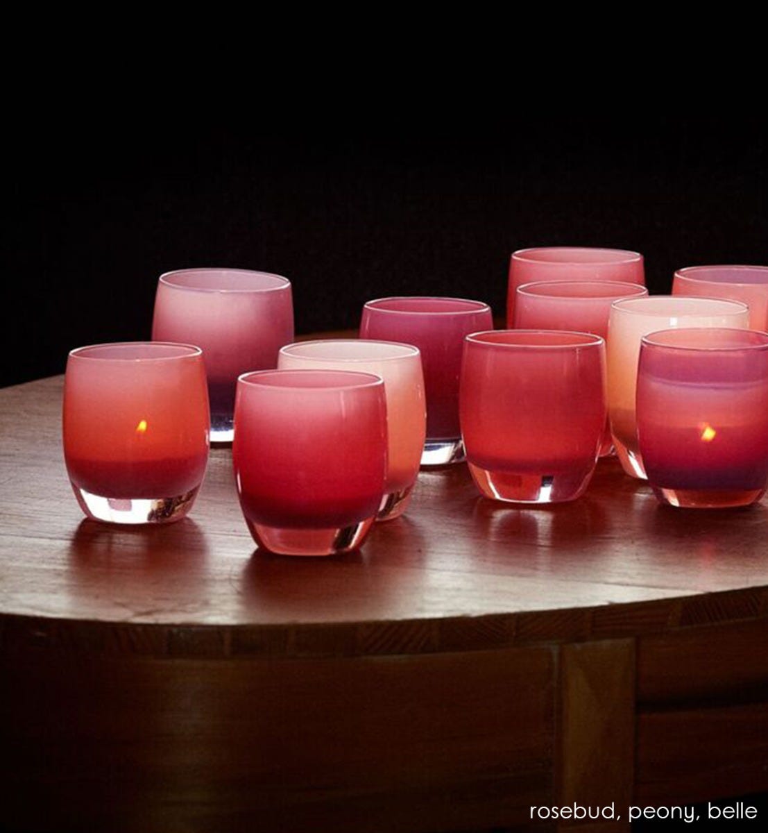 peony pink hand-blown glass votive candle holder. Paired with rosebud and belle on a wood circular table.