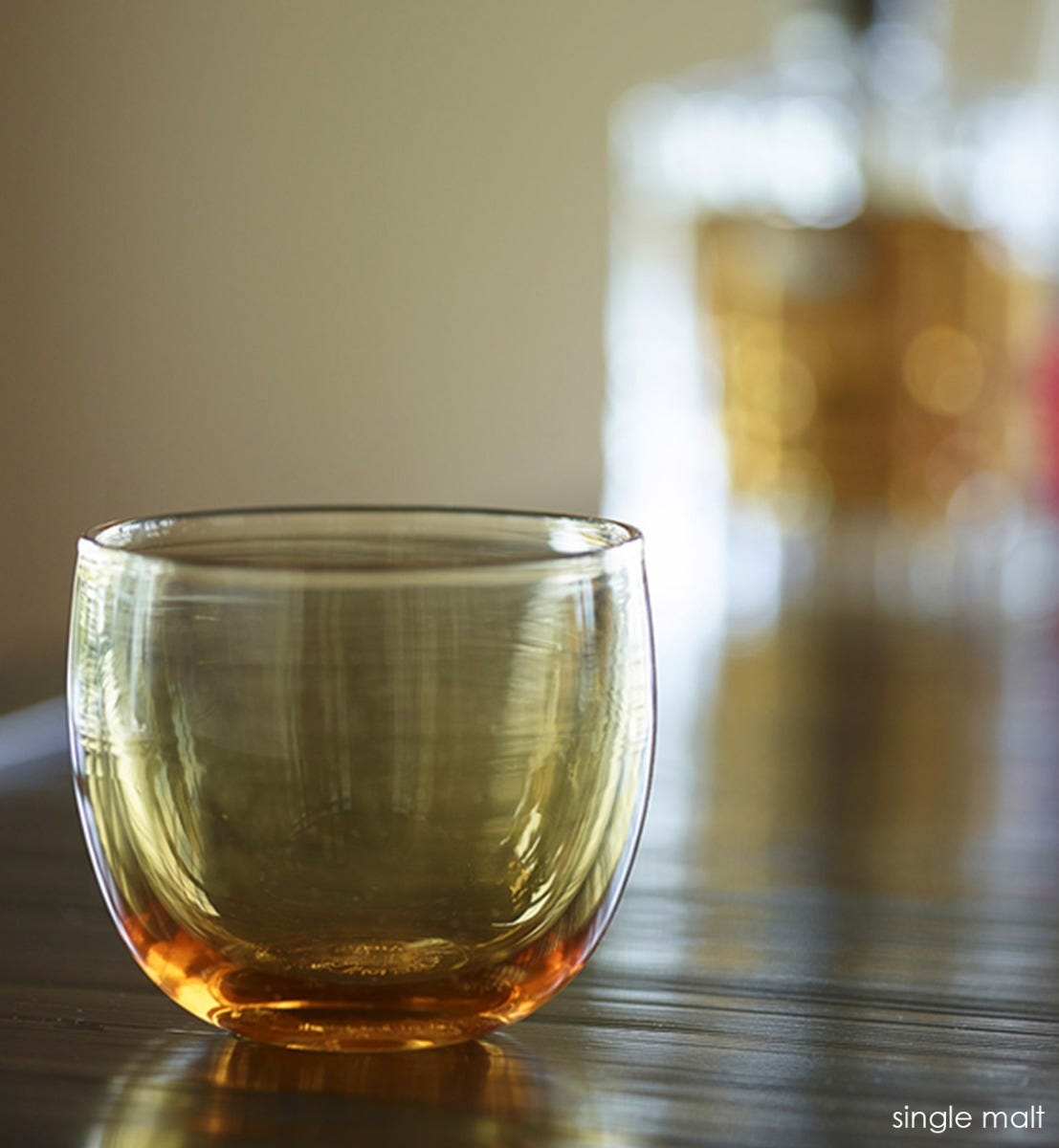 single malt drinker, transparent light amber hand-blown drinking glass.