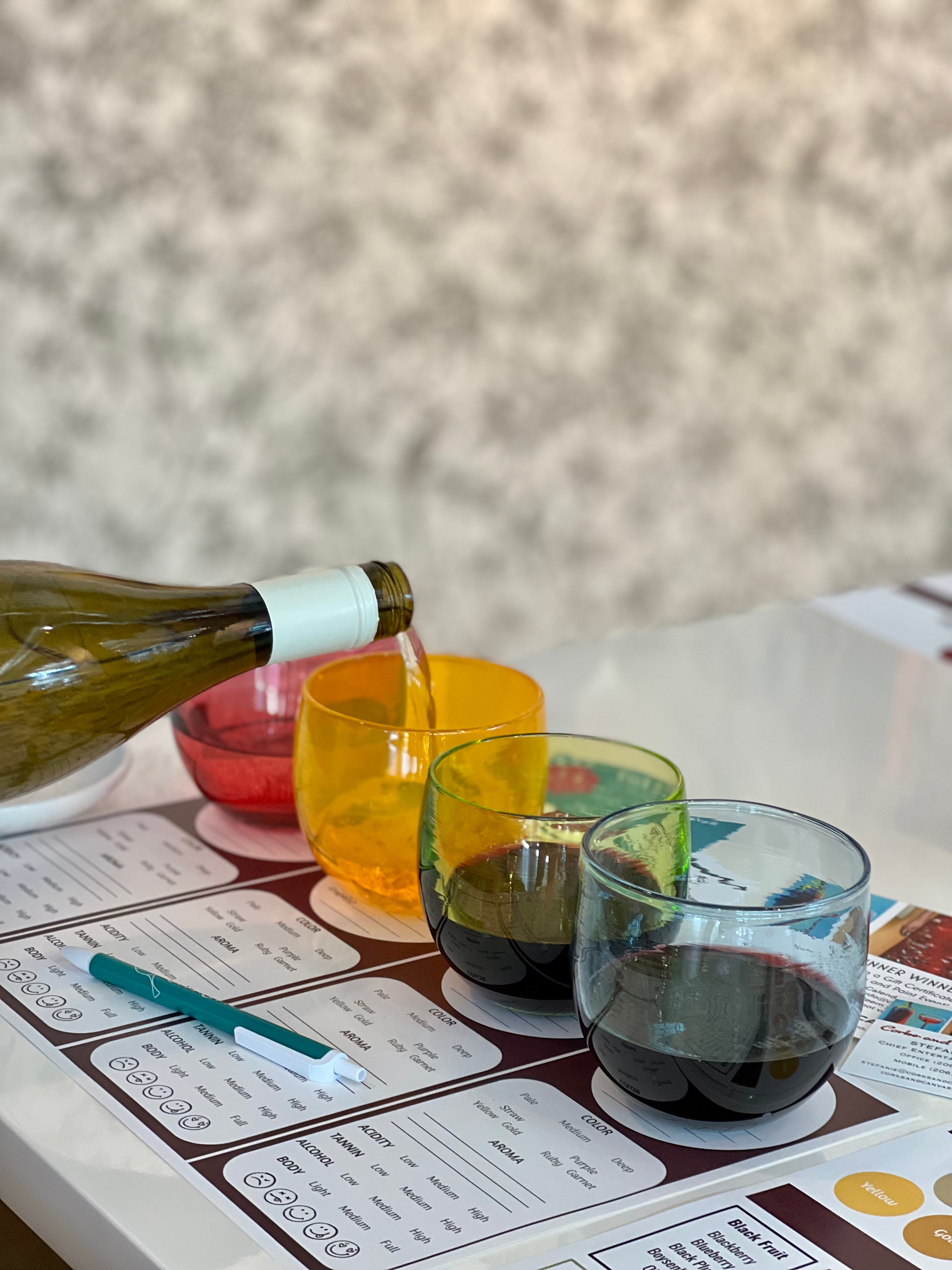 glassybaby wine tasting event, wine being poured into to different glassybaby drinkers next to wine score cards.