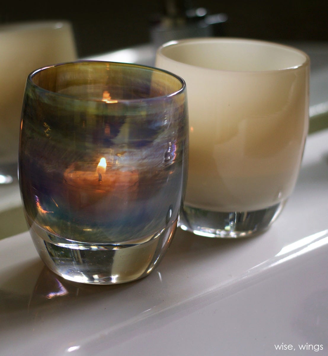 wings, tan grey, hand-blown glass votive candle holder. Paired with wise.